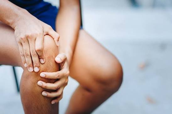 Patient holding a painful knee during arthritis management